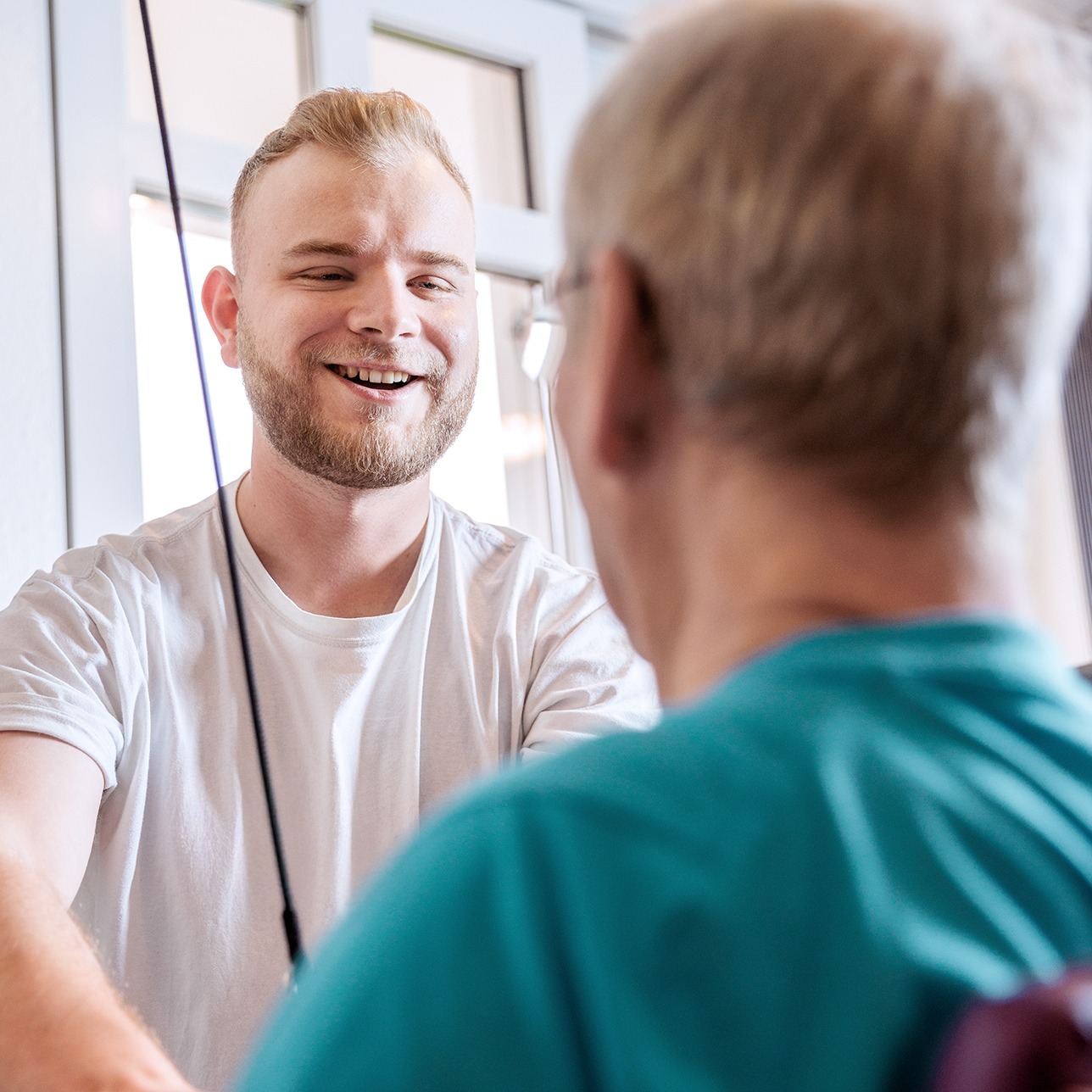 Tom Winter im Gespräch mit einem Patient, Physiotherapie Gütersloh